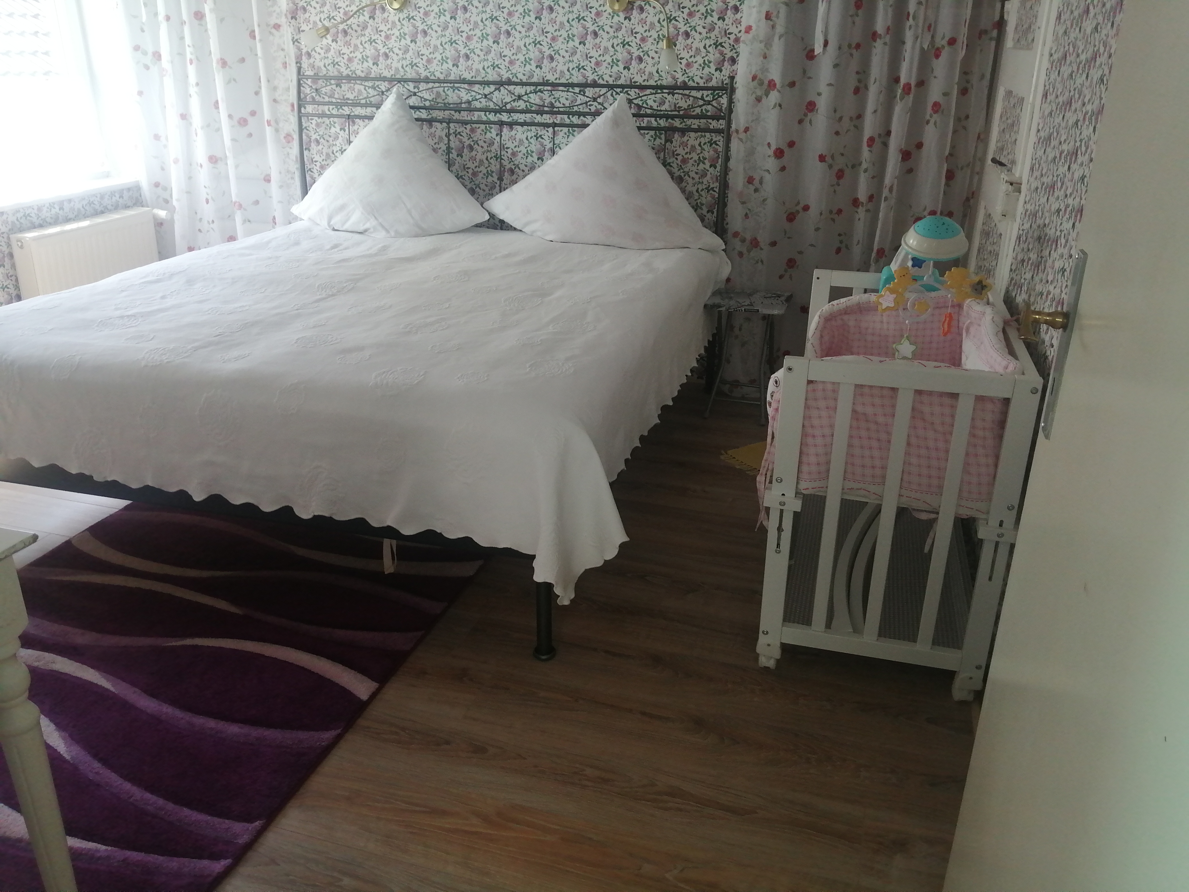 Familienzimmer mit Babybeistellbettchen und hinter der Gardine extra Bett für ein Kind/Jugendlichen