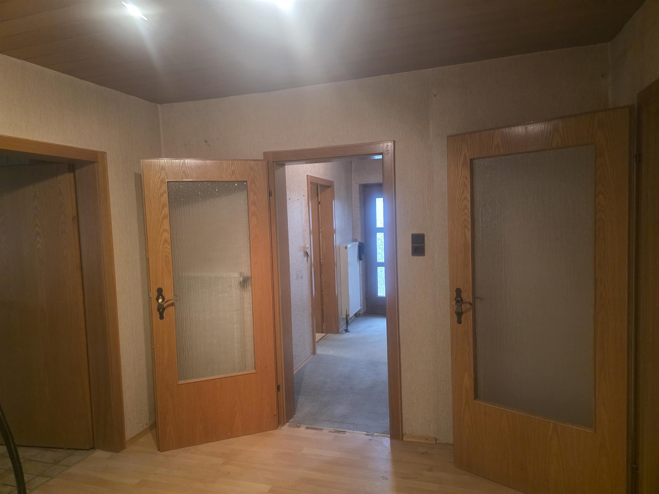 Durchgangszimmer Blick zur Küche, rechts Wohnzimmer, links Badezimmer