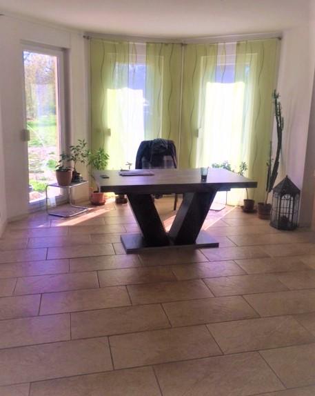 großer Erker im offenen Wohnzimmer mit Grünblick in den Sonnengarten