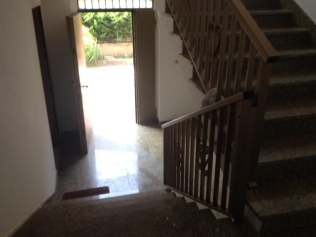 Der Blick vom Treppenhaus auf die geöffnete Haustüre